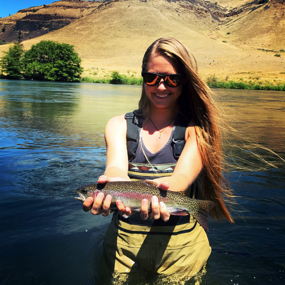 An angler with a beautiful trout on a guided Deschutes day trip.